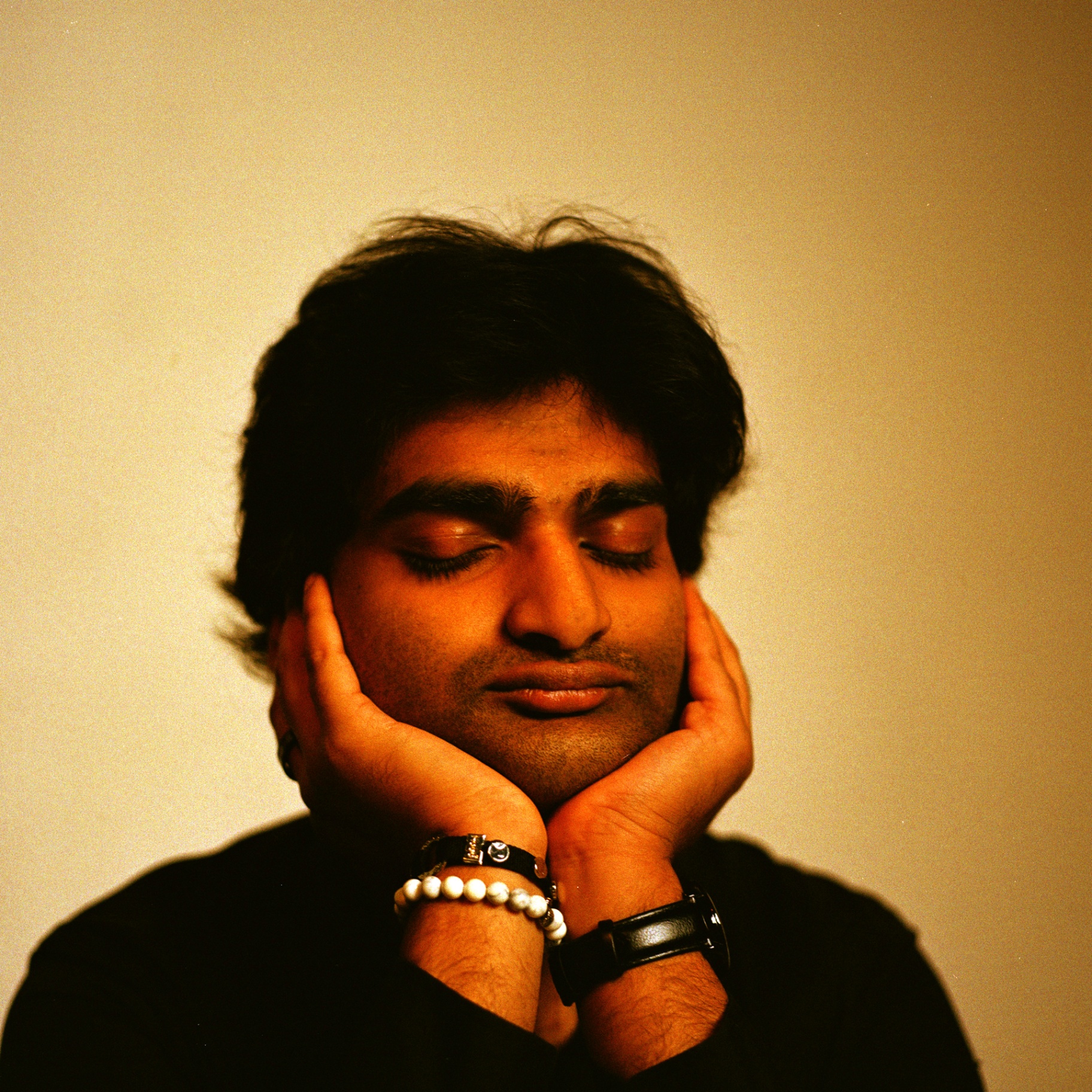 Eshan Agarwal with eyes closed, hands cradling his face